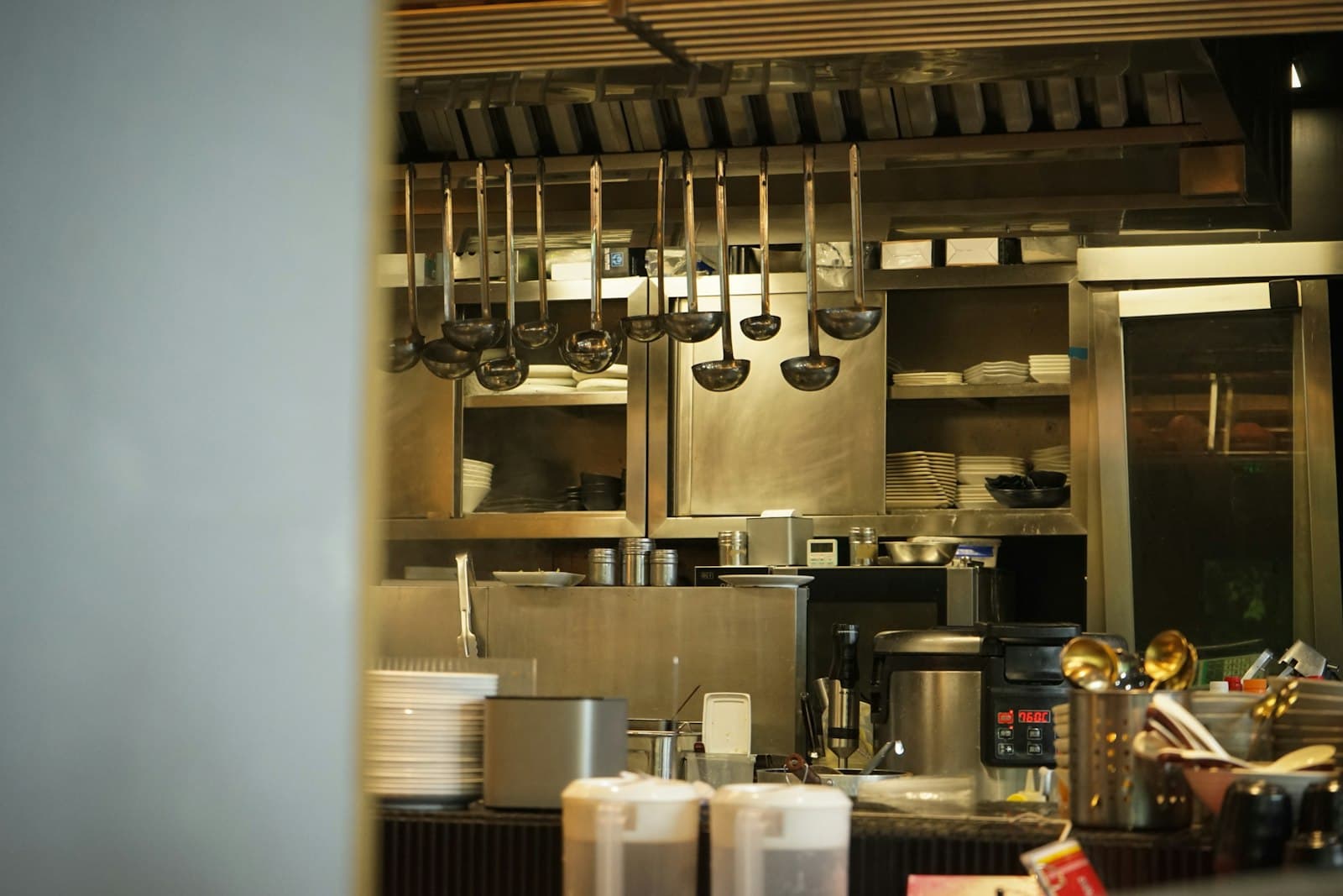 Ladles hanging over the pass in a commercial kitchen